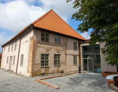 Haus von der Vorderseite mit Eingang rechts, hinten links der Garten