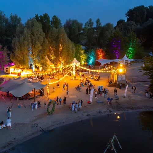 Mittsommer Vibe am Abend. Am Boddenstrand viele bunte Lichter erhellen den Strand