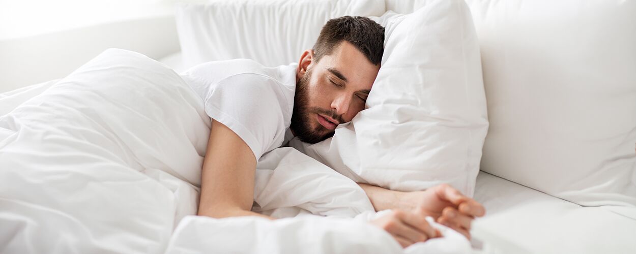 Mann schläft in einem Bett
