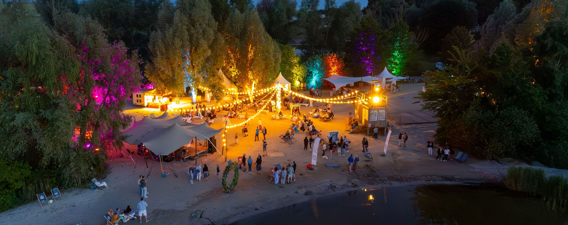 Mittsommer Vibe am Abend. Am Boddenstrand viele bunte Lichter erhellen den Strand
